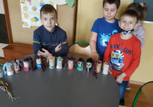 Dzieci pokazują swoje prace z surowców wtórnych.